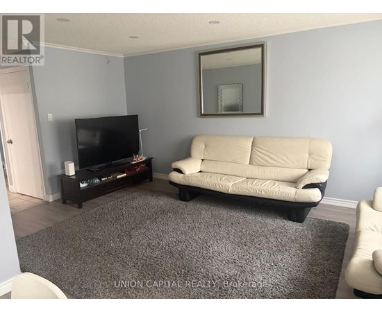 A living room with a white couch and a flat screen TV.