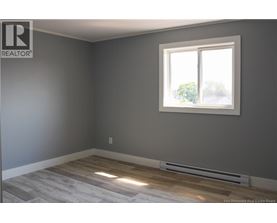 A room with a window and a radiator on the floor.