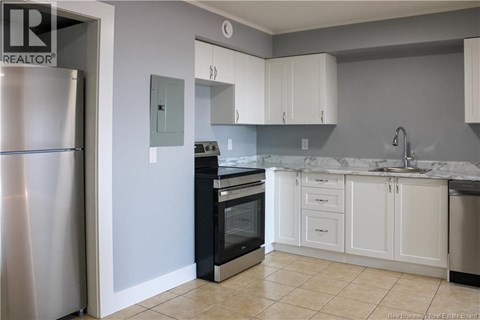 A kitchen with white cabinets and a marble countertop.