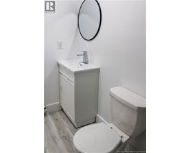 A white toilet sits next to a sink in a small bathroom.