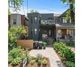 A grey house with a small garden in front.