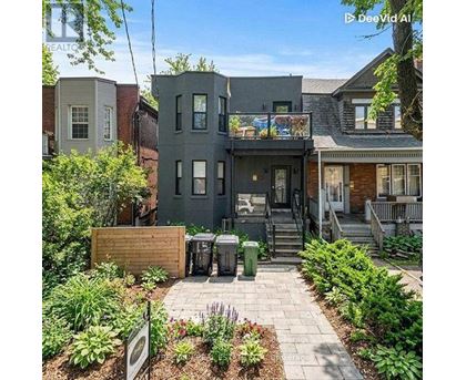 A grey house with a small garden in front.