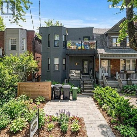 A grey house with a small garden in front.