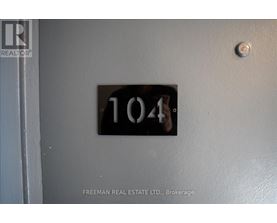 A door with a number 104 on it and a Freeman Real Estate Ltd. logo.