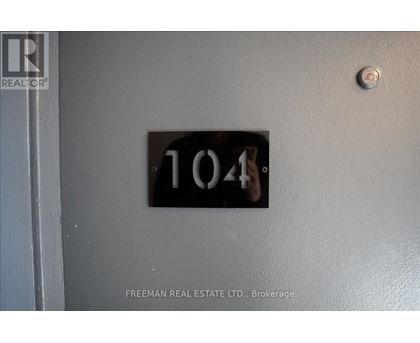 A door with a number 104 on it and a Freeman Real Estate Ltd. logo.