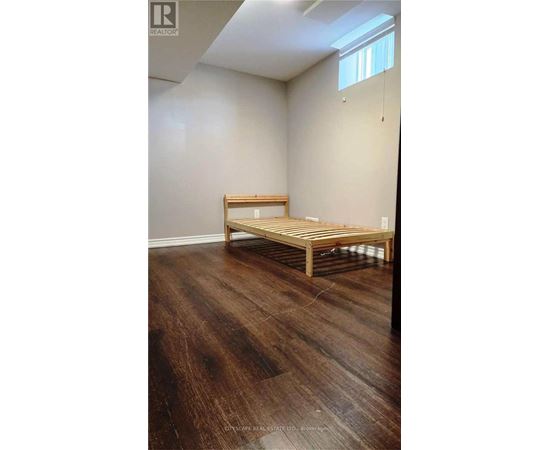 A room with wooden flooring and a bench.