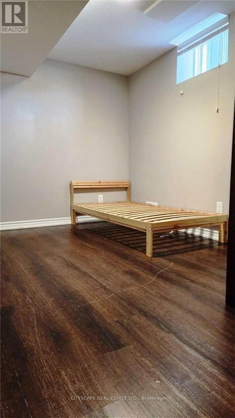 A room with wooden flooring and a bench.