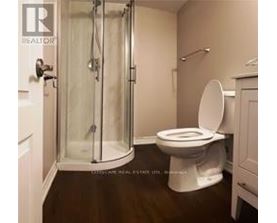 A white toilet in a bathroom with a glass shower door.