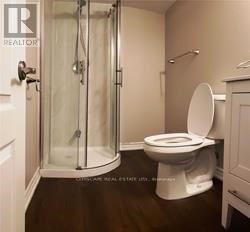 A white toilet in a bathroom with a glass shower door.