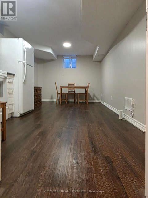 A kitchen with a white refrigerator and wooden floors.