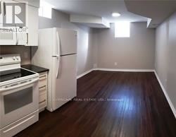 A kitchen with white appliances and wood floors.