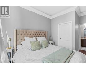 A bedroom with a large bed and a white headboard.