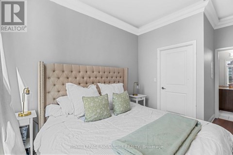 A bedroom with a large bed and a white headboard.