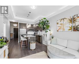 A well-lit kitchen with a breakfast bar and a dining table with chairs.