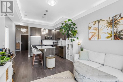 A well-lit kitchen with a breakfast bar and a dining table with chairs.