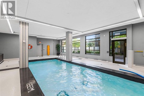 A swimming pool inside a building with a white ceiling.