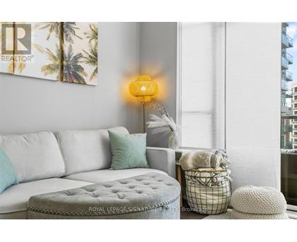 A living room with a white couch and a yellow lamp.