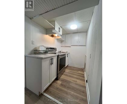 A kitchen with white cabinets and a wooden floor.