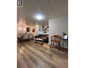 A living room with a wooden floor and a white wall.