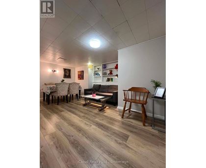 A living room with a wooden floor and a white wall.