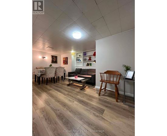 A living room with a wooden floor and a white wall.