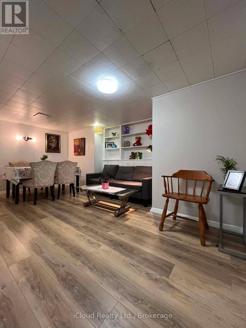 A living room with a wooden floor and a white wall.