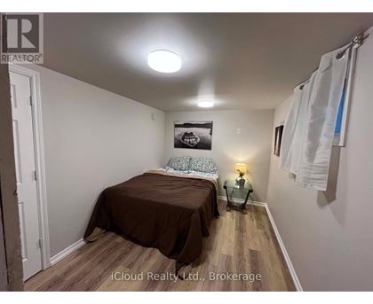 A bedroom with a bed, a nightstand, and a lamp.