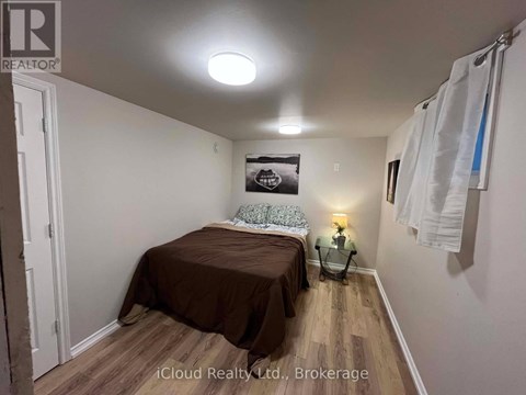 A bedroom with a bed, a nightstand, and a lamp.