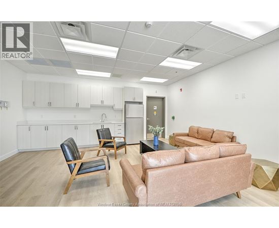 A living room with a brown couch and a chair.