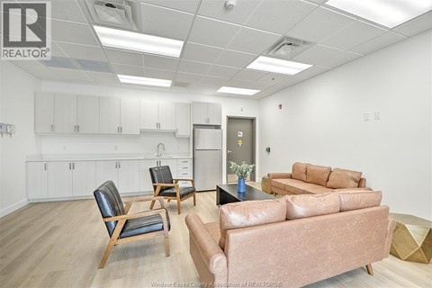 A living room with a brown couch and a chair.