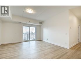 A spacious room with a sliding glass door and wooden flooring.