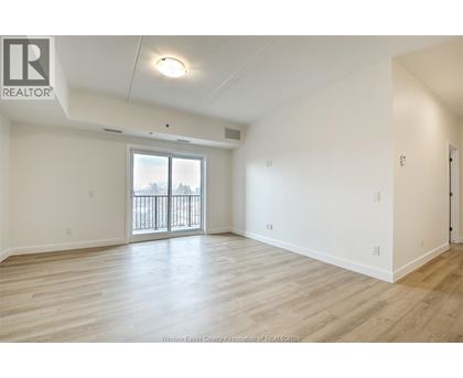 A spacious room with a sliding glass door and wooden flooring.