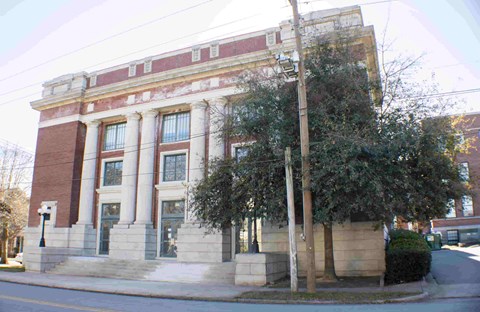 A red brick building with white trim and a black door.