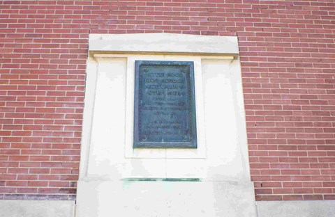 A plaque on a brick wall commemorates the 50th anniversary of a certain event.