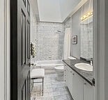 A bathroom with a toilet, sink, and tub.