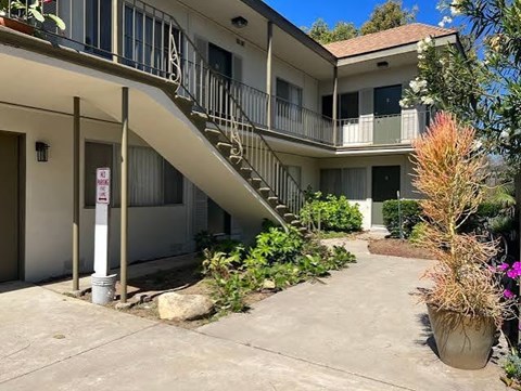 A building with a staircase and a sign on a pole.