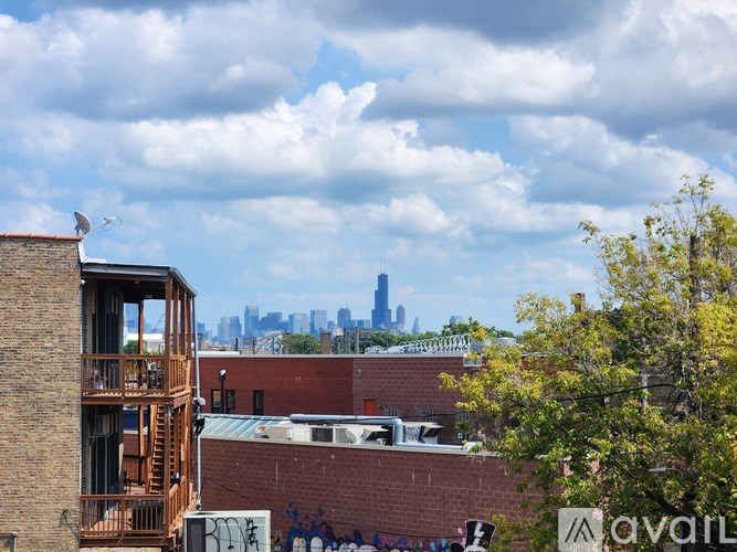 A cityscape with buildings and a cloudy sky.