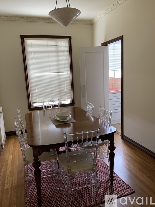 A dining room with a table and chairs.
