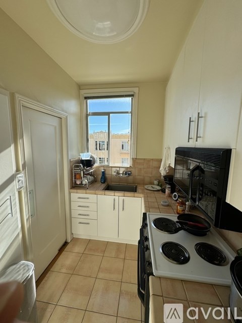 A kitchen with a stove top oven and a window.