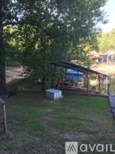 A small gazebo is situated in a grassy area.