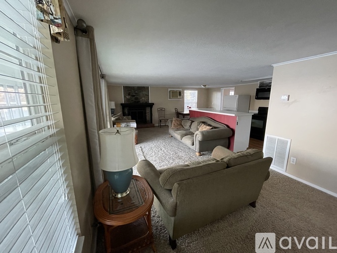 A living room with a couch, a table with a lamp, and a fireplace.
