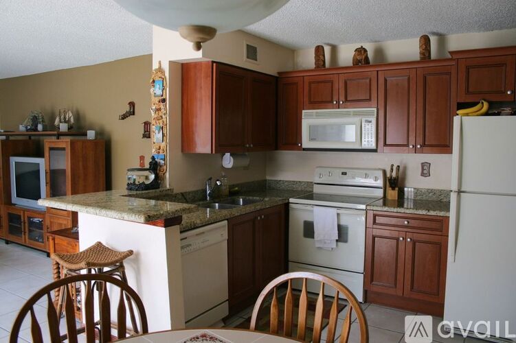 A kitchen with brown cabinets and a white refrigerator.