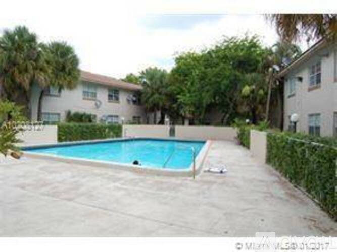 A swimming pool in a backyard surrounded by a fence.