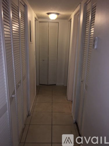 A long hallway with white doors on both sides.
