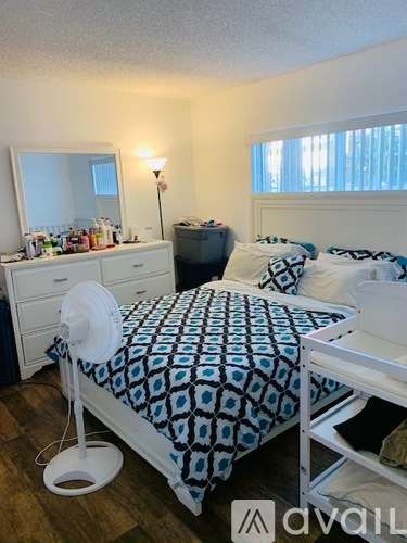 A bedroom with a bed, a dresser, and a mirror.