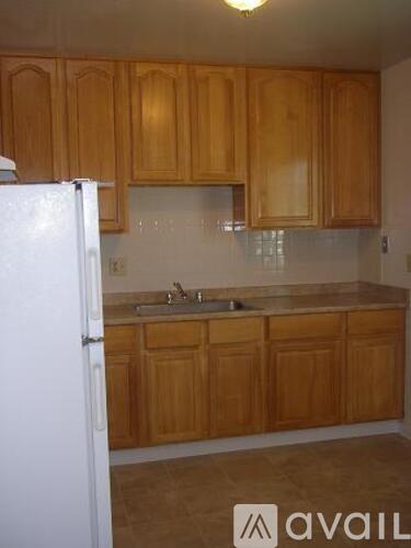A kitchen with wooden cabinets and a white refrigerator.