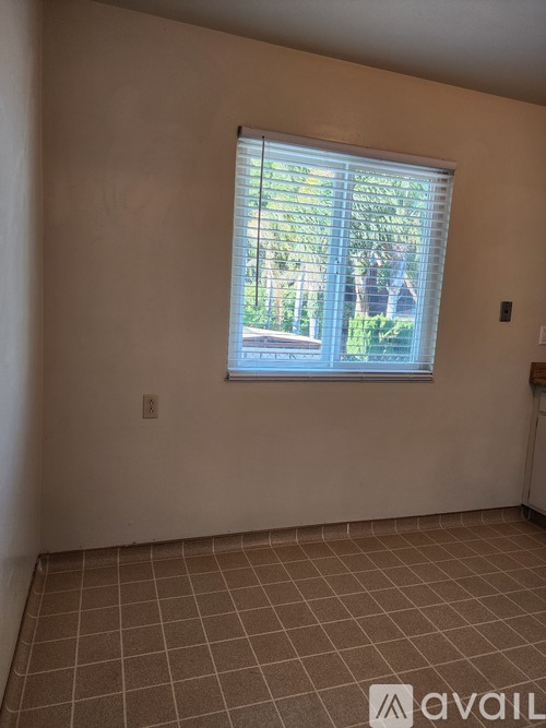A room with a window and tiled floor.