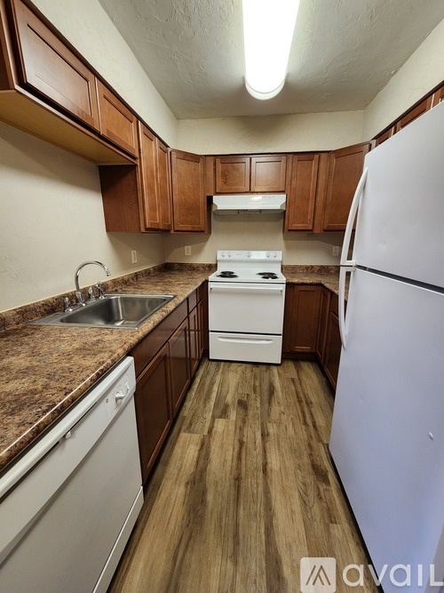 A kitchen with brown cabinets and a white fridge.