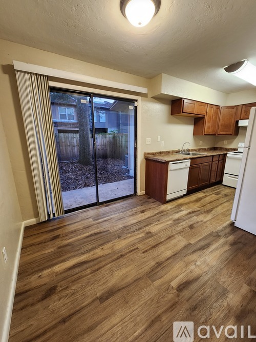 A kitchen with wooden floors and white appliances.