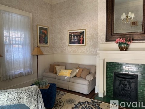 A living room with a white couch and a fireplace.